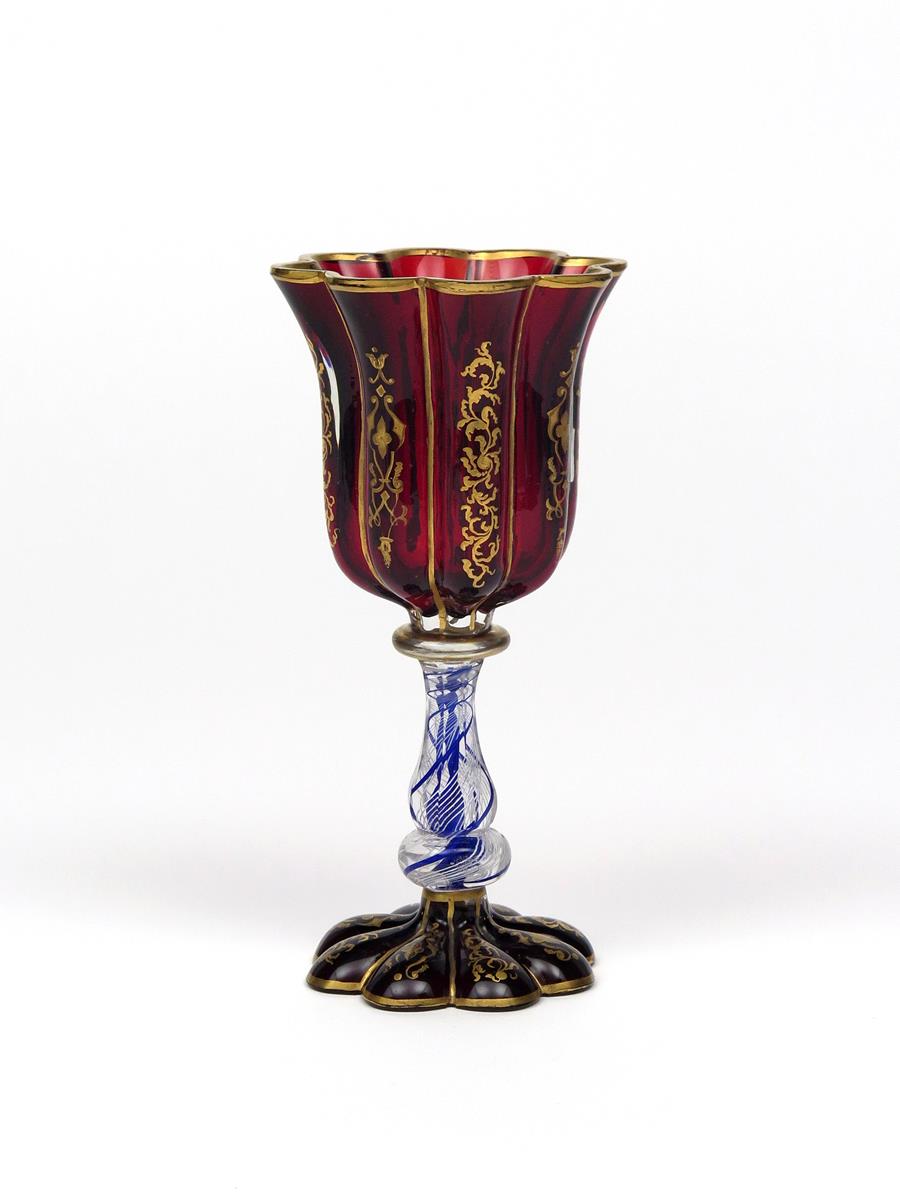 A Bohemian glass goblet 19th century, the fluted ruby glass bowl gilded with foliate scrolls, raised