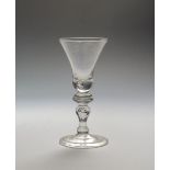 A baluster wine glass c.1720, the bell bowl with a tear to the base, above an annulated knop and