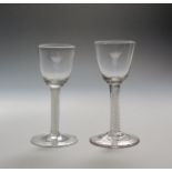 A pair of wine glasses c.1770, one English, one Dutch, the round funnel bowls later engraved with