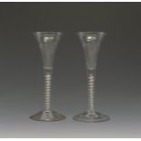 A pair of wine glasses c.1760, with fine drawn trumpet bowls rising from opaque twist stems, 17.5cm.