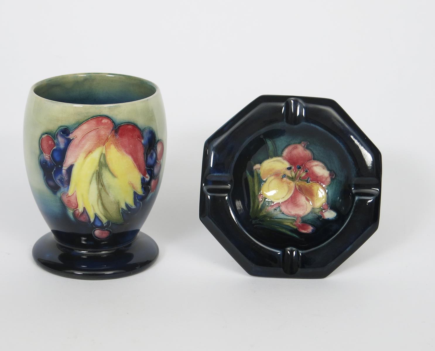 'Leaf and Berry' a Moorcroft Pottery vase designed by William Moorcroft, footed cylindrical form,