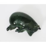 An Ewenny Pottery model of a sleeping pig, covered in a mottled green glaze, incised to side 'Y