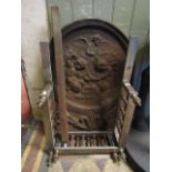 A heavy vintage cast iron fire back of arched form with relief detail of winged cherubs with hammers