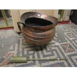 An Arts & Crafts copper cauldron shaped coal scuttle with loop handles and splayed steel tripod