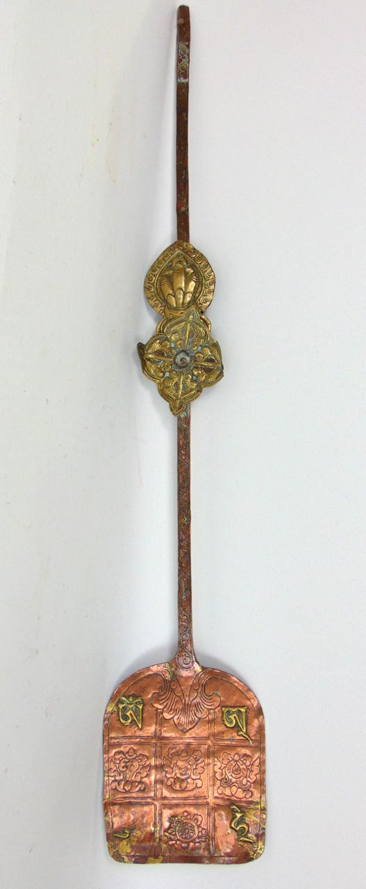 An interesting Tibetan copper shovel with brass relief decoration; together with an antique