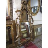 A reproduction Chippendale style gilt framed wall mirror, the rectangular bevelled edge plate