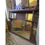 A late 19th century carved oak overmantle mirror incorporating three mirror plates, further carved