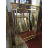 A reproduction wall mirror of rectangular form, the gilt moulded frame enclosing bevelled edge