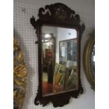 A Georgian wall mirror, the mahogany frame with fret carved outline and gilded flowering basket