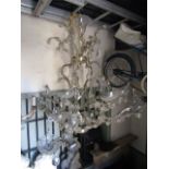 A pair of twelve branch chandeliers festooned with moulded glass flower heads and tear shaped