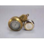 A pocket barometer held within a brass protective case and a contemporary desk watch/paperweight -