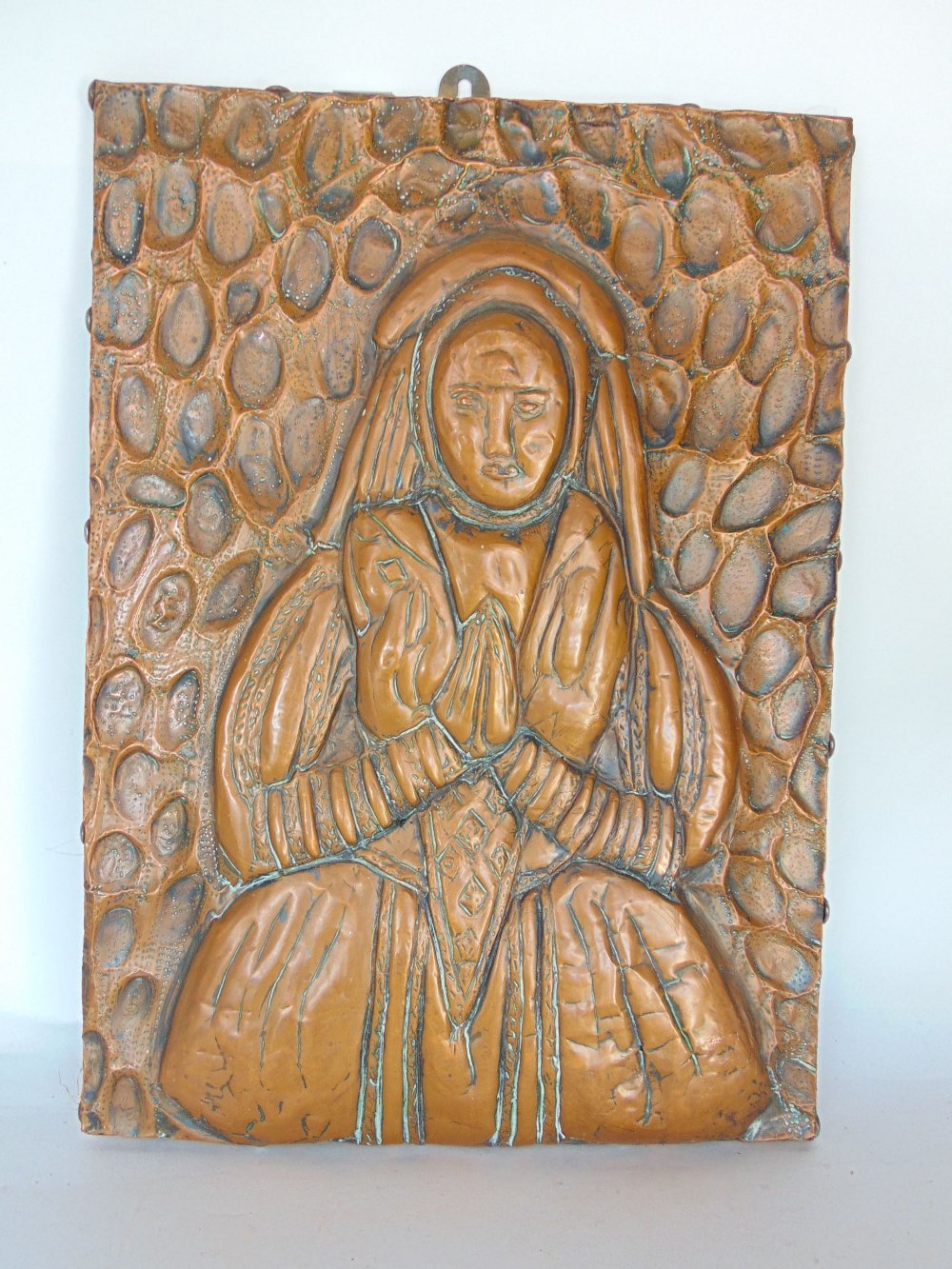 19th century embossed copper panel of a female character praying, with abstract surround, 39 x 28