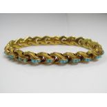 A Victorian yellow metal bracelet set with turquoise cabochons and engraved decoration to each link,