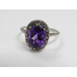 An amethyst ring with diamond surround, in unmarked white gold, size K, 3.5g