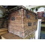 A good vintage wicker laundry/travelling basket with rising lid and sturdy steel work fittings, 80