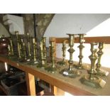 A good selection of eight pairs of 18th century brass candlesticks to include petal base, ejector,