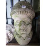 A weathered carved natural stone novelty garden sculpture in the form of a male character, head