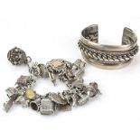 A silver cuff bracelet (116g), together with a charm bracelet with twenty four charms, some silver