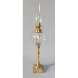 An interesting 19th century brass oil lamp, with globe glass reservoir upon a barley twist column in