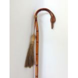 A ladies bamboo crook handled walking cane terminating with a swans head knop