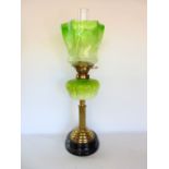 A 19th century brass and glass oil lamp, with lobed green glass shade decorated with flowers upon an