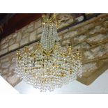 Gilt brass prismatic drop ceiling light, six bulb fitting with cast garland swags and finial's
