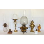 A collection of seven oil lamps to include a good cast metal baluster lamp in the French empire