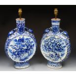 A pair of oriental blue and white two handled moon flasks with painted decoration of equestrian