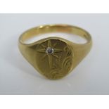A gentleman's signet ring in 18ct gold set with a single diamond with starburst decoration, size