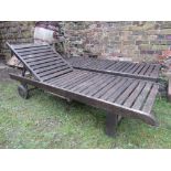 A pair of weathered contemporary hardwood garden/pool side loungers with adjustable slatted seats