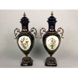 A pair of continental blue ground two handled vases and covers with gilt detail, encrusted floral