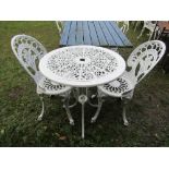 A cream painted cast aluminium garden terrace table of circular form with decorative pierced