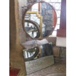 A gilt framed wall mirror of circular and shaped form with foliate detail, together with a frameless