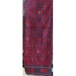 Meshwari runner, decorated with geometric red medallions upon a navy blue ground, 250 x 60cm