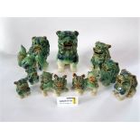 A quantity of oriental green glazed dogs of fo of various sizes and in various positions, 25 cm tall