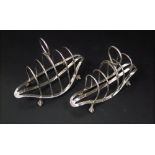 Graduated pair of Victorian boat shaped lancet toast racks with four divisions upon paw feet,