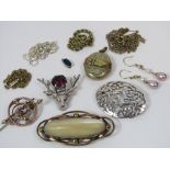 A mixed lot to include an engraved locket with embossed buckle decoration, two silver brooches, a