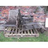 A pair of contemporary weathered teak folding steamer type garden armchairs with slatted seats and