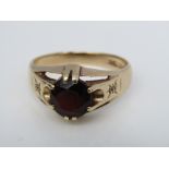 A 9ct gentleman's ring, claw set with a faceted garnet and diamonds to the shoulders, size Y/Z, 6.