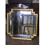 An art deco style wall mirror with bevelled edge plates, within a stepped moulded gilt frame, 90