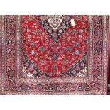 Good Persian Kashan carpet decorated with floral scrolled patterns around a central navy blue