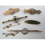 An art deco style bar brooch in 15ct gold set with pale blue stones in trefoil formation, together