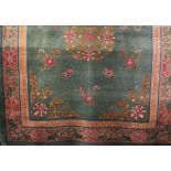 Chinese wool carpet decorated with various medallions and butterflies upon a Celandon green