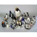 A collection of ceramic and glass models of penguins including a Royal Dux example, 15 cm tall, a