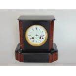 Small two train black slate mantle clock with 10 cm enamelled dial, 22 cm high