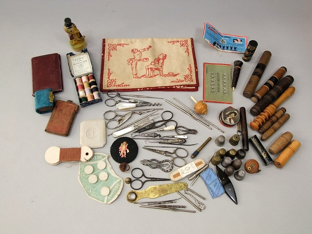 A collection of Victorian and later sewing effects, needle cases, cottons, embroidered pouch showing