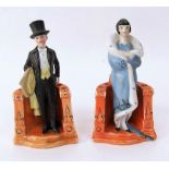 A pair of 1920s German humorous figure groups, possibly hat pin holders or cigarette holders, in the