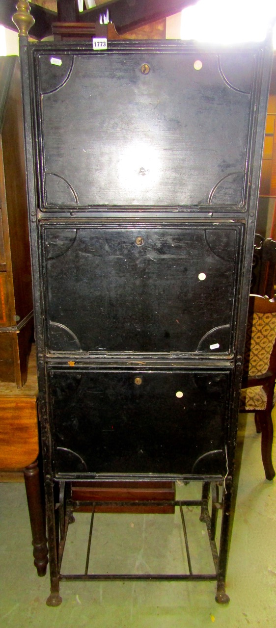 A tower of three deed boxes in tin, set within a decorative iron framework, 60cm wide x 170cm high