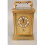 Gilt brass carriage clock with shaped cast case, the gilt mask fitted with inset enamel Arabic