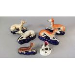 Two pairs of 19th century Staffordshire inkwells modelled as recumbent greyhounds, together with a